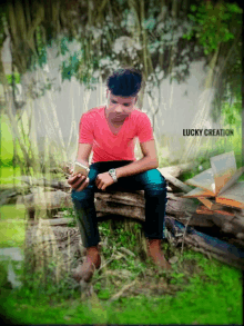 a man in a red shirt is sitting on a log looking at his phone with lucky creation written on the bottom right