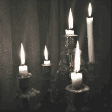 a black and white photo of candles lit in candlesticks