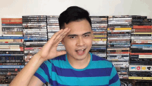 a man salutes in front of a stack of dvds including one that says ' life fi ' on it