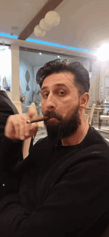 a man with a beard holds a cigar in his mouth