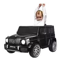 a little girl is sitting in a black mercedes amg car