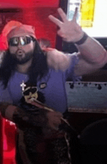 a man with long hair and a beard is wearing sunglasses and giving a peace sign