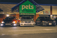 three cars parked in front of a pets at home pet shop and pet grooming