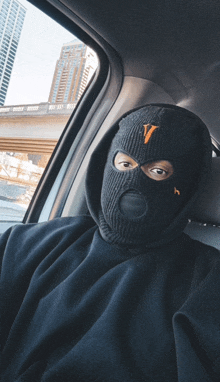 a person wearing a black ski mask with a v on it