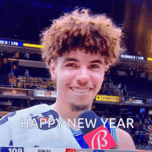 a man with curly hair is smiling and holding a microphone with the words happy new year written below him