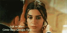 a man adjusts a woman 's hair with the words aşk ve mavi written below