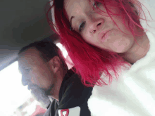 a man with a beard and a woman with pink hair wearing a white sweatshirt with the letter c on it