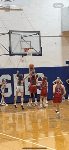 a basketball game is being played in a gym with a crop button on the bottom right