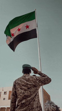 a soldier salutes in front of a flag