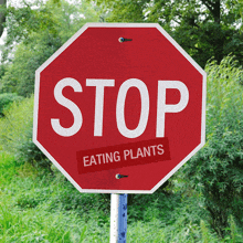 a stop sign with a sticker that says eating plants on it