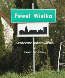 a green sign that says pewel wielka with a silhouette of a city on it