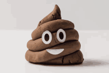 a pile of brown poop with white eyes and a smile on its face