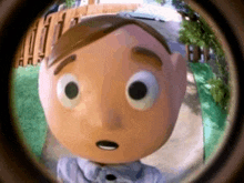 a cartoon character is looking through a peephole at the camera .