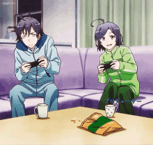 a boy and a girl are sitting on a couch playing a video game with a bag of chips on the table