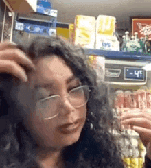 a woman wearing glasses and a wig is standing in a store .