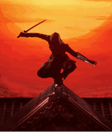 a silhouette of a ninja holding a sword on top of a building