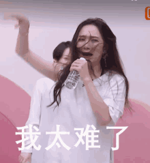 a woman is singing into a microphone with chinese writing on the bottom