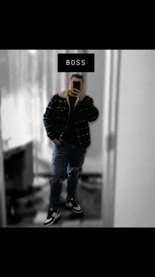 a man taking a selfie in front of a mirror with the word boss on the bottom