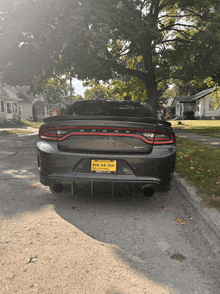 a dodge charger is parked on the side of the road with a yellow license plate