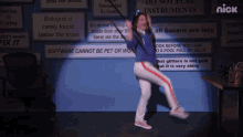 a woman is dancing in front of a wall with signs that say do not play instruments and software cannot be pet or worn