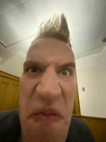 a close up of a man 's face with a mohawk