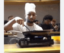 a man in a chef 's hat is cooking food on a stove with the letter e on it