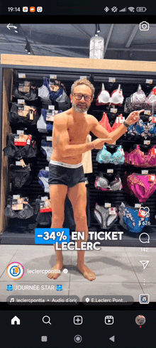 a man without a shirt is standing in front of a rack of underwear