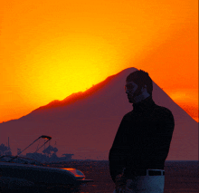 a man is standing in front of a sunset with a boat in the foreground