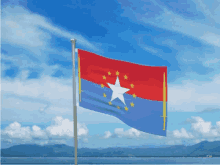 a red and blue flag with a white star on it is flying in the wind