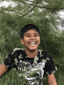 a young boy wearing a shirt that says gmc is smiling