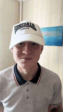 a young man wearing a white lonsdale hat