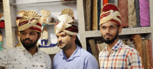 three men wearing turbans are standing in front of a shelf that says vivo x60 pro zeiss