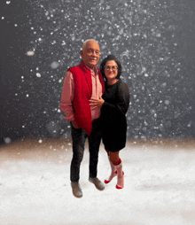 a man in a red vest stands next to a woman