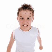 a young boy in a white tank top is making a very angry face