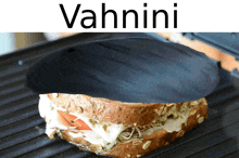 a sandwich is being cooked on a grill with the words vahnini above it