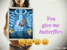 a woman is holding a picture of a x-ray with butterflies on it and the words " you give me butterflies " below it