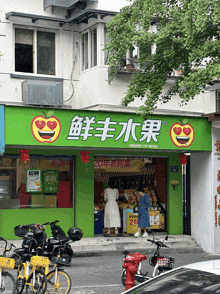 a store front with a green sign that says ' 新鲜 水果 '