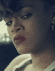 a close up of a woman 's face with red lips and earrings in a car .