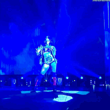 a wrestler is standing on a stage with a blue light behind him and the words the next thing on the bottom