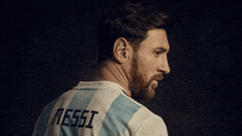 a man wearing a messi jersey looks to his left