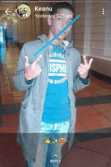 a man wearing a blue shirt that says isphe is giving a peace sign