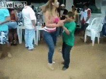 a woman and a boy are dancing in front of a crowd with the words live leak on the bottom