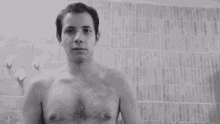 a black and white photo of a shirtless man holding a soap bar