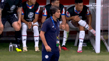 a group of soccer players are sitting on a bench and one of them has a shirt that says copa america on it