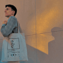 a man is carrying a tote bag that says something about maps