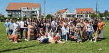 a large group of people are posing for a photo in a field