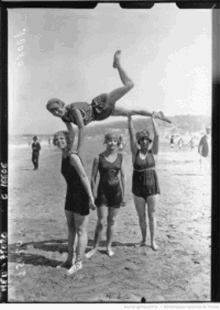 a black and white photo of a group of women on a beach with the number e1051 on the bottom