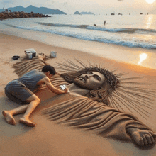 a man is laying on a beach making a statue of jesus