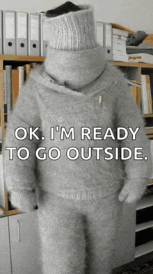 a person wearing a sweater with the words ok i 'm ready to go outside on it