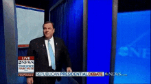 a man in a suit and tie is standing in front of a blue screen that says republican presidential debate on it